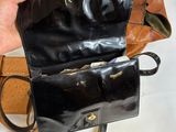 a person holding a black purse on a white table