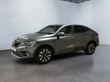un SUV gris garé dans une grande pièce aux murs blancs
