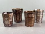 four silver cups sitting on top of a table next to each other