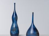 trois vases bleus posés sur une table blanche