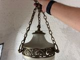 une personne qui tient une lampe suspendue au plafond