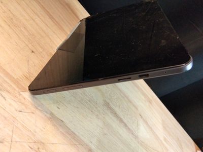 un ordinateur portable noir posé sur une table en bois