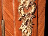 a wooden cabinet that has a brass handle on it