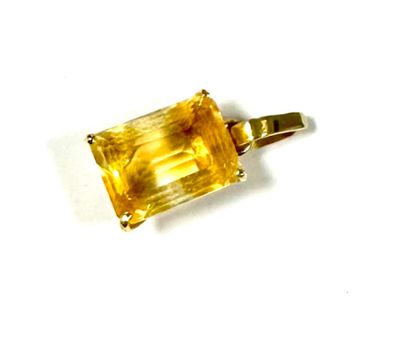 a close up of a yellow stone pendant on a white surface