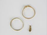 deux bagues en or et une petite bague en diamant posées sur une surface blanche