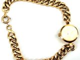 an image of a close up of a gold bracelet with a watch on it
