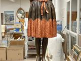 une statue représentant une femme en robe, posée sur un socle