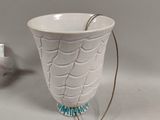a white vase with a spoon in it on a table