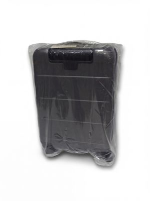 une valise emballée dans du plastique posée sur une surface blanche