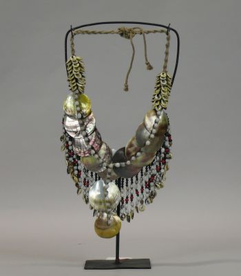 a close up of a necklace on a stand on a white background