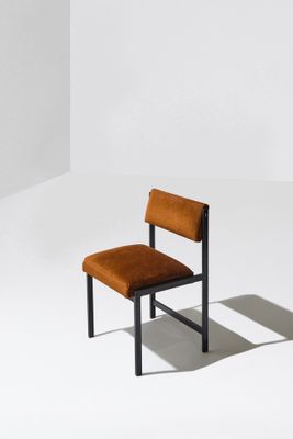une image représentant une chaise placée dans une pièce blanche, avec une ombre sur le sol