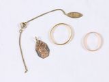 two rings, a necklace, and a ring on a white surface