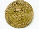 une vieille pièce d'or sur laquelle figure une couronne, posée sur un fond blanc