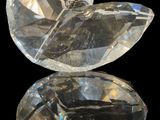 a close up of a pair of clear crystal stones on a black surface