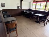 tables and chairs are lined up in a restaurant with a large window