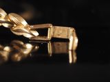 a close up of a gold chain on a black surface