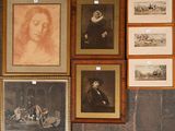 many framed pictures on the wall of this room