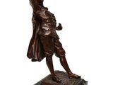 bronze statue of a man with a hat and coat on a marble base