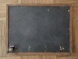 a blackboard on the floor with a black handle