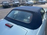 a blue convertible car parked on the side of the road