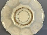 a white plate with a brown rim on a gray table
