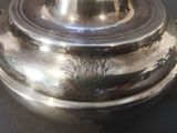 a silver plate with a lid that has a design on it