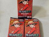 Trois paquets contenant chacun une pièce de Dragon Ball sont posés sur une table.
