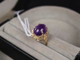 une bague sertie d'une pierre violette, dans un écrin