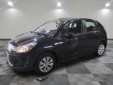 la petite voiture noire est garée sur un carrelage à carreaux