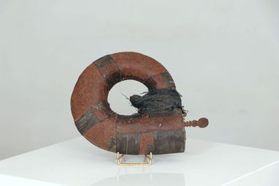 a sculpture of a bird sitting on top of a piece of wood