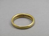 a close up of a gold wedding ring on a table