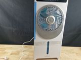 a white and blue fan sitting on top of a wooden table