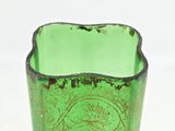a green glass vase with a purple flower on it