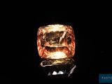 un diamant orange est représenté sur une surface noire