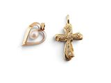 deux croix en or et un pendentif en forme de cœur en perle sur fond blanc