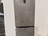 a silver refrigerator sitting on a pallet in a warehouse