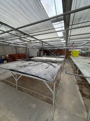 many tables and benches under a roof in a building