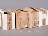three empty wine glasses sitting next to a box of empty wine glasses