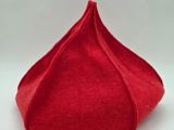 un gros plan d'un chapeau rouge posé sur une surface blanche