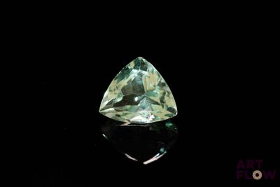 a close up of a green diamond on a black surface