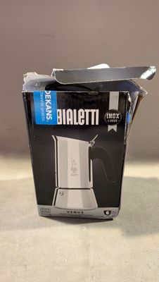 emballage d'une cafetière à lait posée sur une table à côté d'une tasse