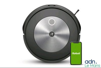 un gros plan d'un Roomba avec un téléphone portable à côté