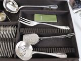 a tray that has silverware in it on a table