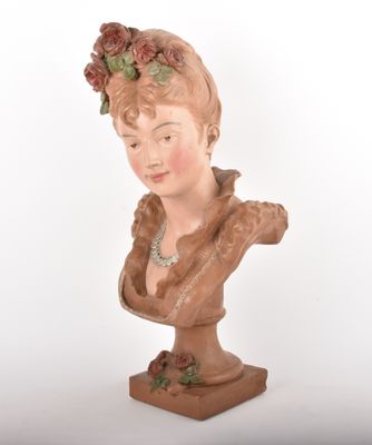 a clay bust of a woman with flowers on her head