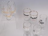 bottles and glasses are lined up on a white surface