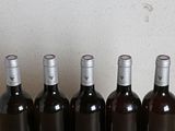 six bottles of wine are lined up in a row on a table