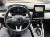the interior of a car with a steering wheel and a tablet on the dashboard
