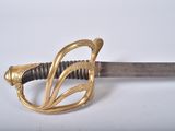 an image of a sword with a gold handle on a white surface