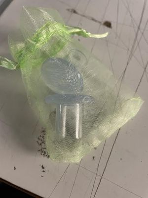 un petit sac orné d'un ruban vert posé sur une feuille de papier