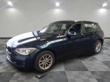 a picture of a blue bmw car in a showroom